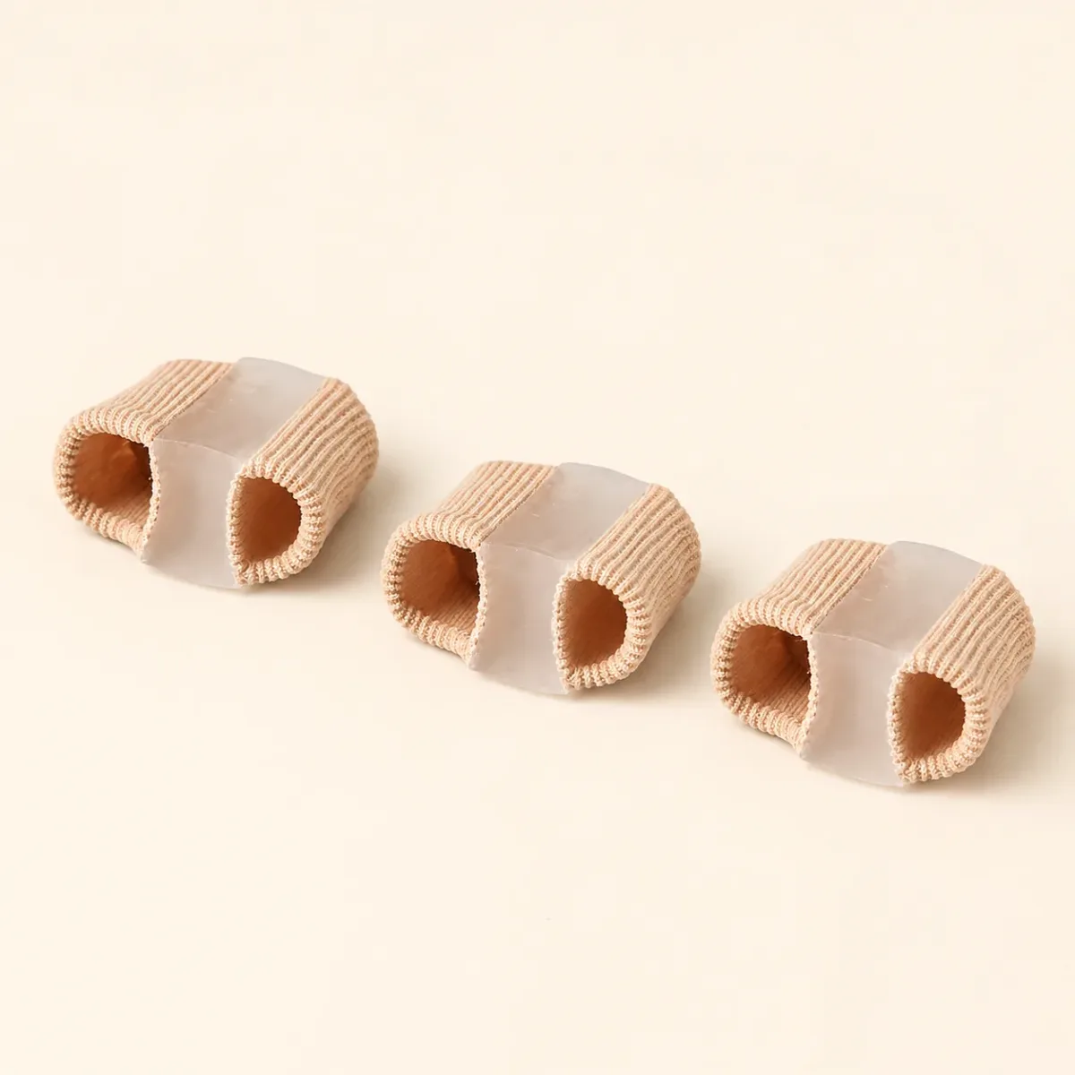 Three beige ribbed-fabric gel separator tubes on a plain cream background
